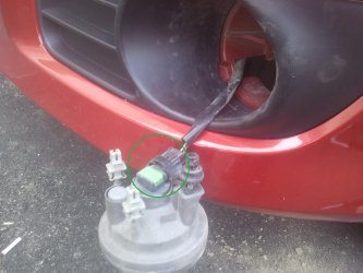 На фото – открученная ПТФ. Зеленым отмечен цоколь, которые предстоит разъединить для доступа к лампе