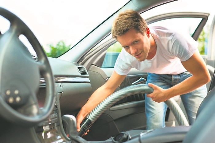 Мужчина пылесосит салон авто Мужчина пылесосит салон авто